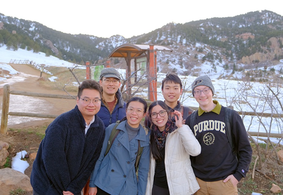 Six students posing in front of brown and green hills