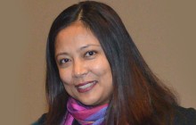 photo of Gyami Shrestha with long dark hair on brown background