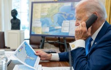 President Biden looking at a print out of maps