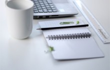 black pencil on notepad next to white coffee mug