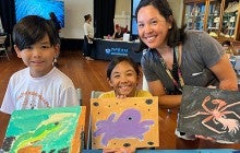 woman with children displaying their paintings