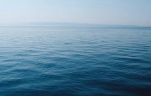 body of water under blue and white sky at daytime