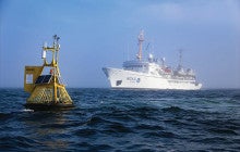 yellow buoy and a white boat on the ocean