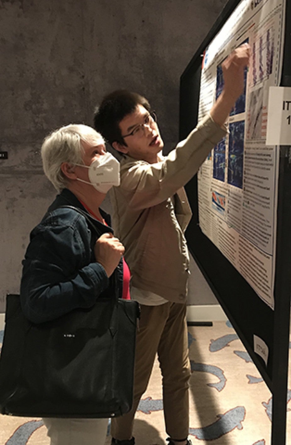 CEDAR student explains his research to Dr. Larisa Goncharenko, MIT Haystack Observatory, at the workshop.