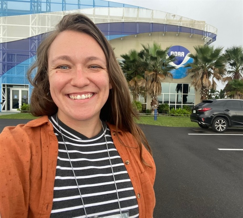 picture of Cheyenne Stienbarger in front of building with NOAA logo