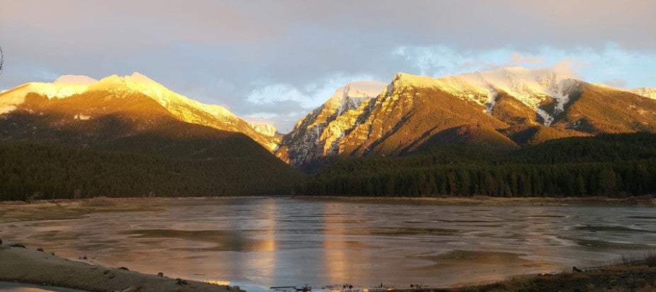 lake surrounded by hills with blue sky