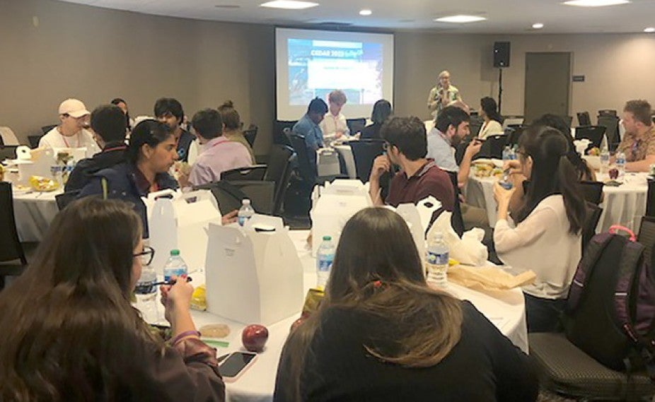 people eating lunch while watching a speaker