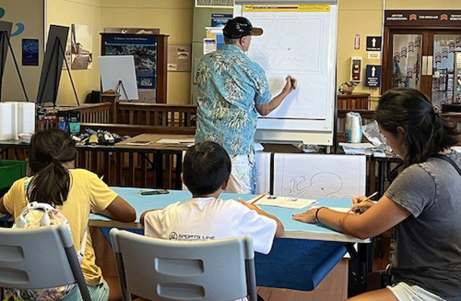 man drawing on white board