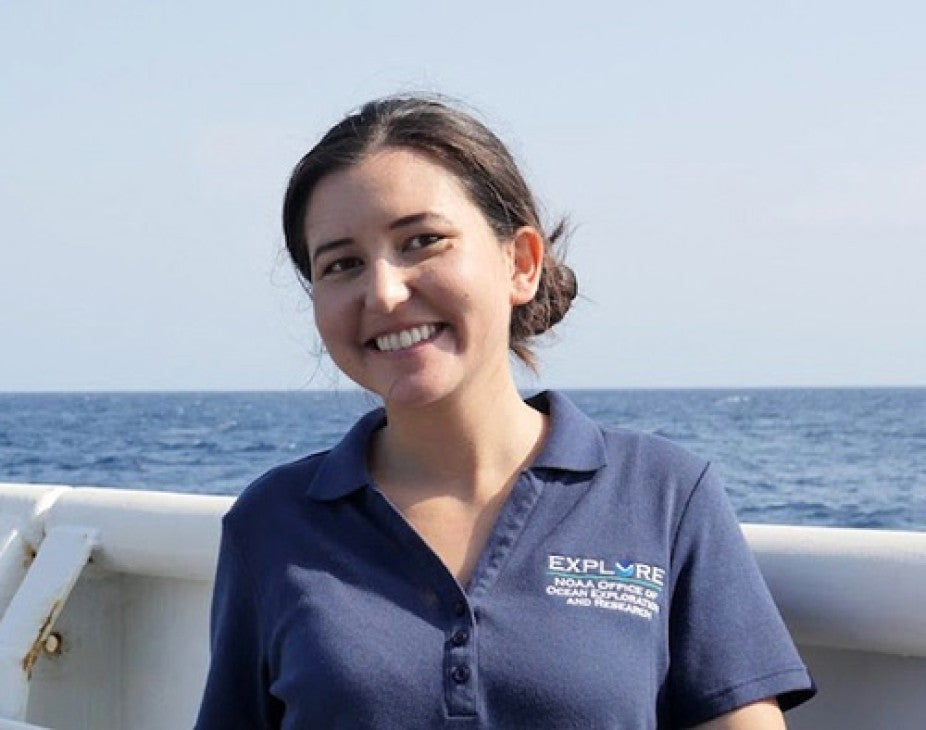 woman wearing blue t-shirt with ocean background