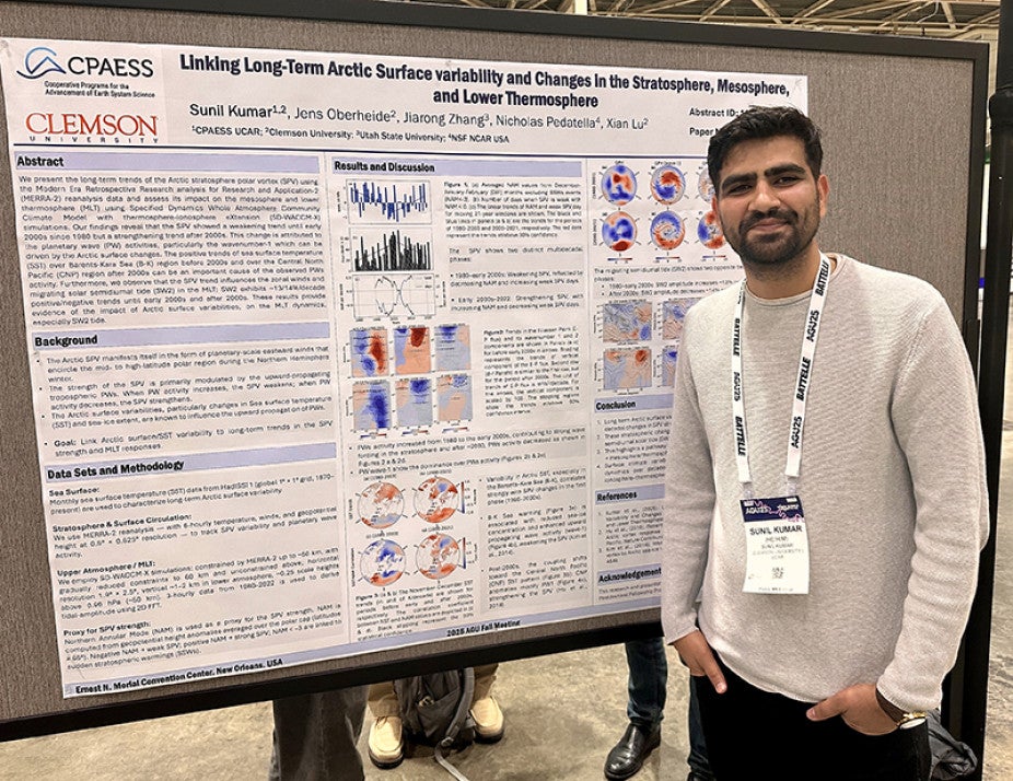 man standing in front of his poster presentation