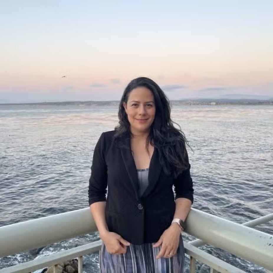 woman with long dark hair standing on a boat