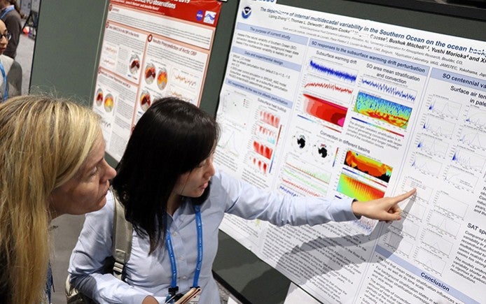 Two women looking at a poster