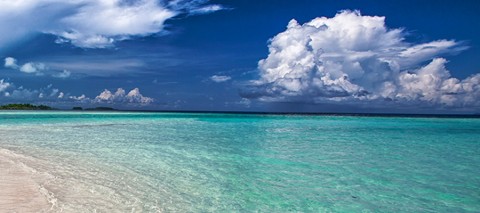 Beach with blue ocean and blue sky with clouds