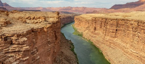 river running through red canyon walls