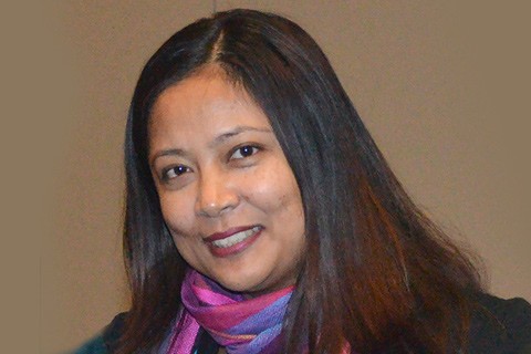 photo of Gyami Shrestha with long dark hair on brown background