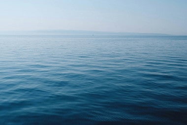 body of water under blue and white sky at daytime
