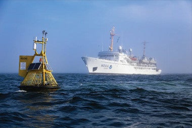 yellow buoy and a white boat on the ocean